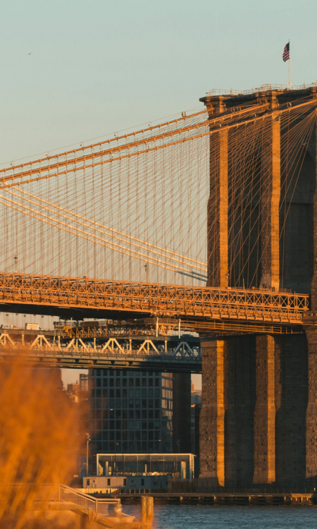Brooklyn Bridge bei warmem Abendlicht über dem East River in New York City