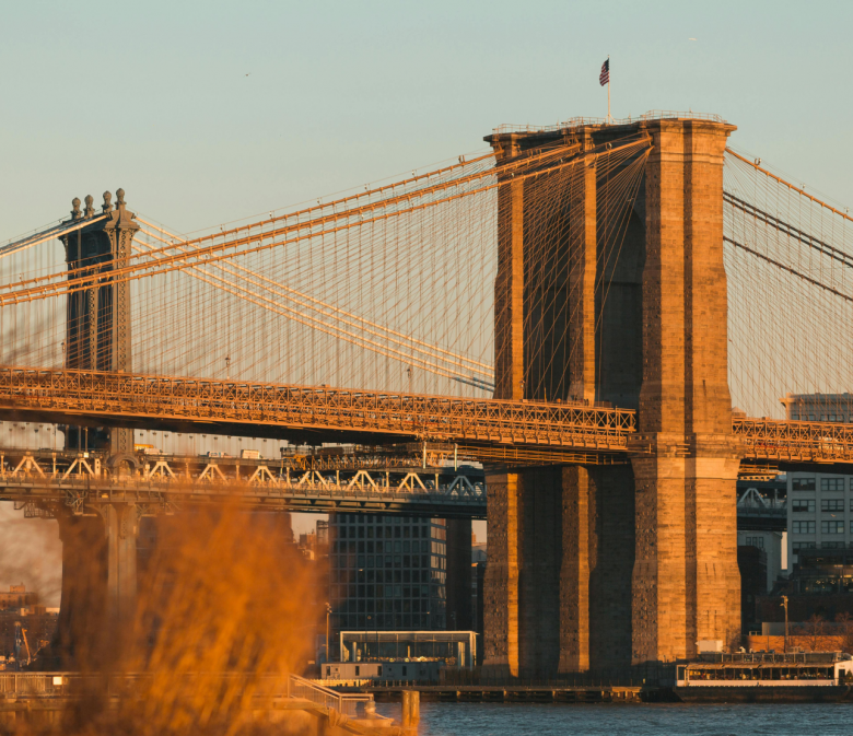 Brooklyn Bridge bei warmem Abendlicht über dem East River in New York City