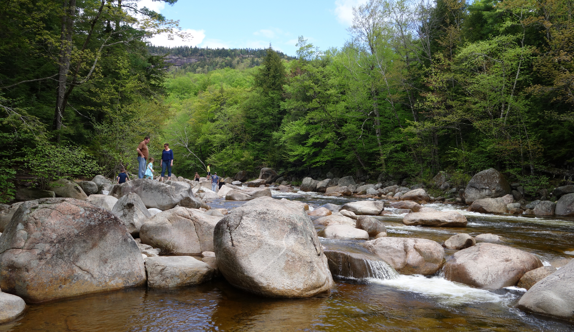 Felsiger Flusslauf mit klarem Wasser und Waldlandschaft nahe Lake Winnipesaukee
