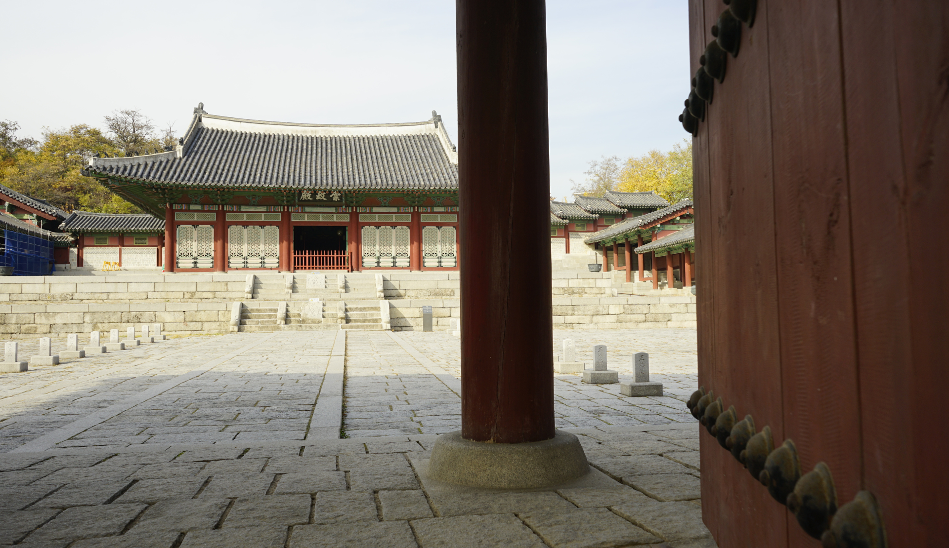 Blick durch eine rote Holzsäule auf den Innenhof und das Hauptgebäude des Gyeonghuigung Palastes in Seoul