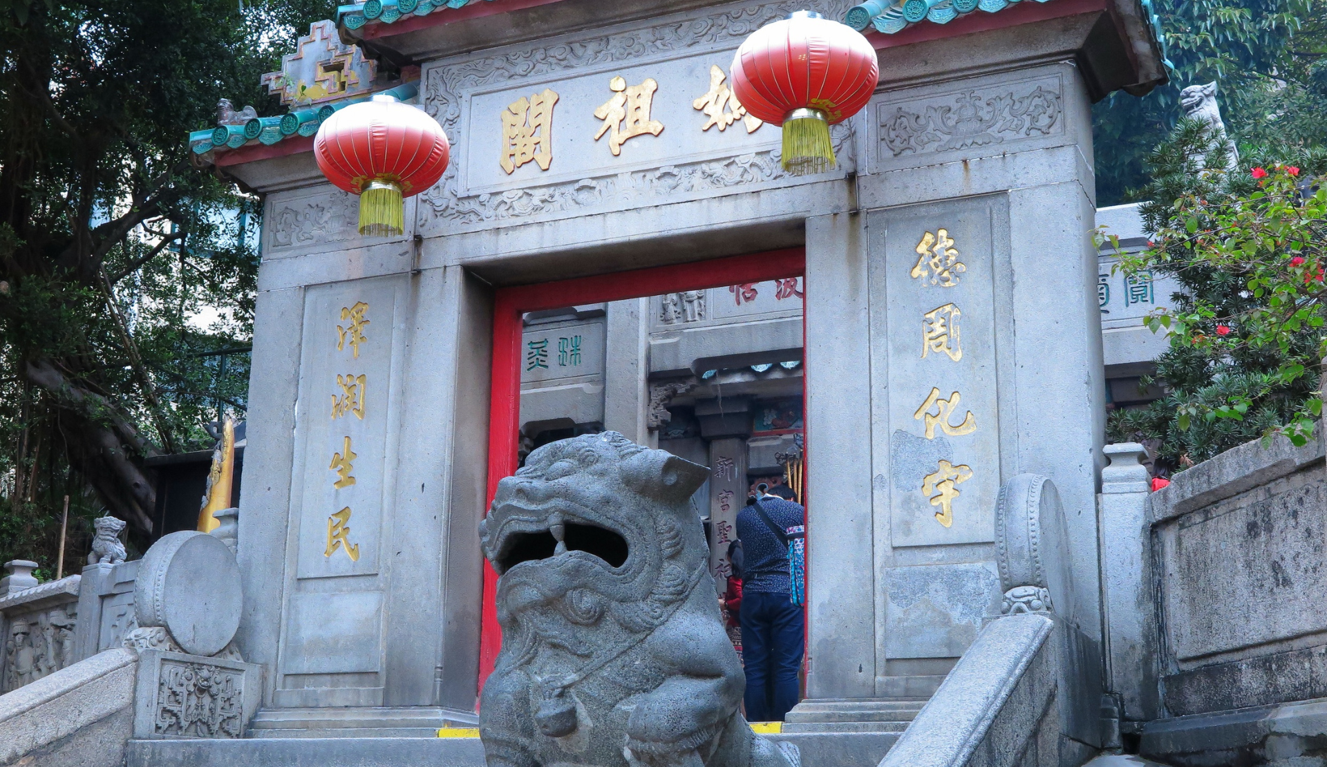 Eingang des A-Ma Tempels in Macau mit Steinlöwe und roten Laternen