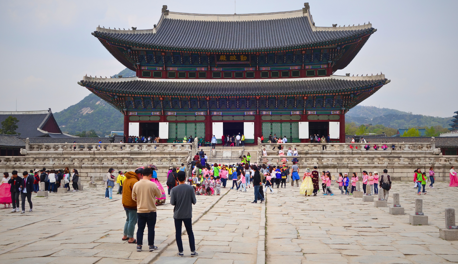 Blick auf den Hauptthronsaal Geunjeongjeon des Gyeongbokgung-Palastes in Seoul mit vielen Besuchern auf dem Vorplatz