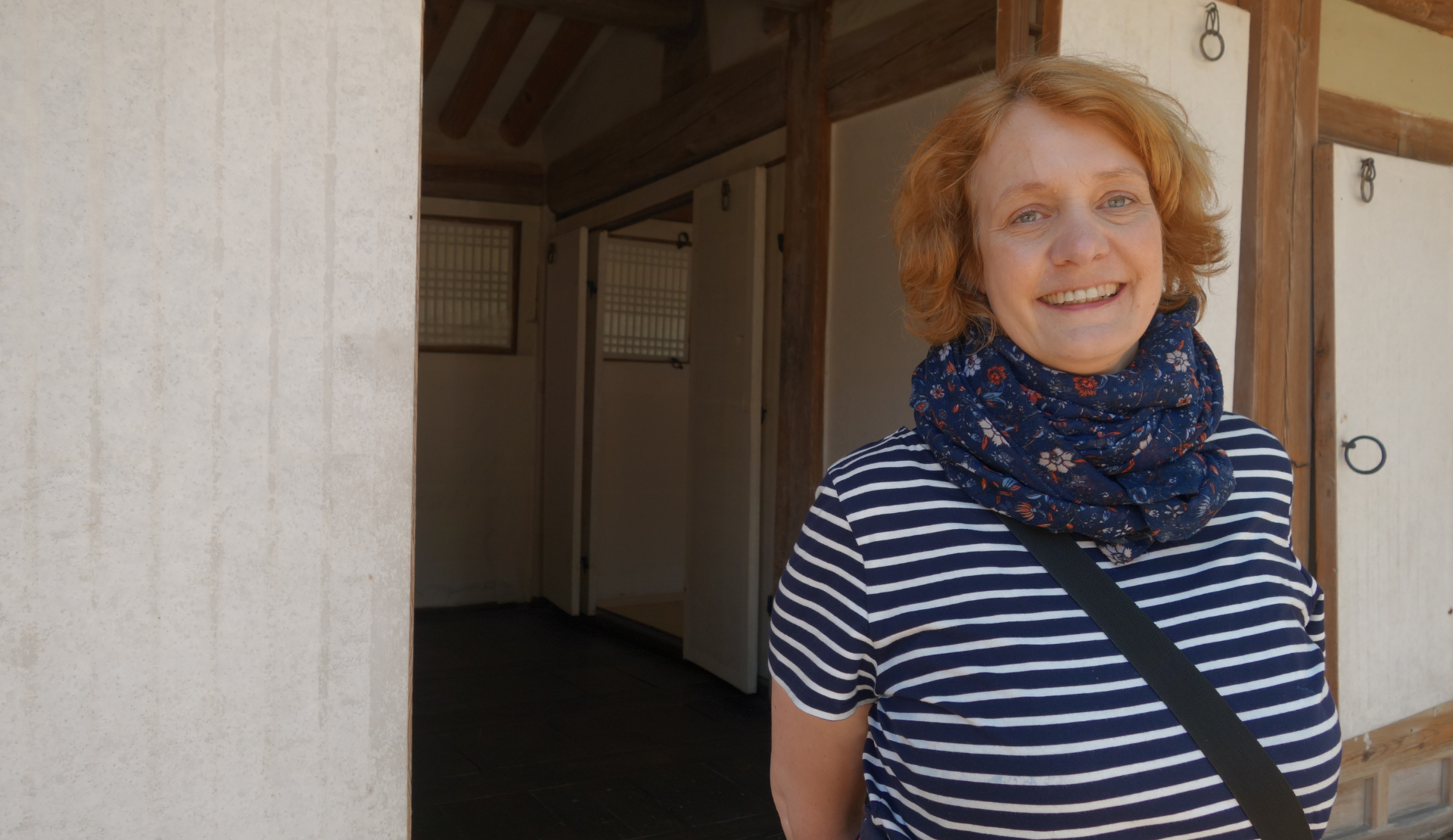 Bloggerin Peggy lächelt vor einem traditionellen Holzgebäude im Secret Garden des Changdeokgung Palastes in Seoul