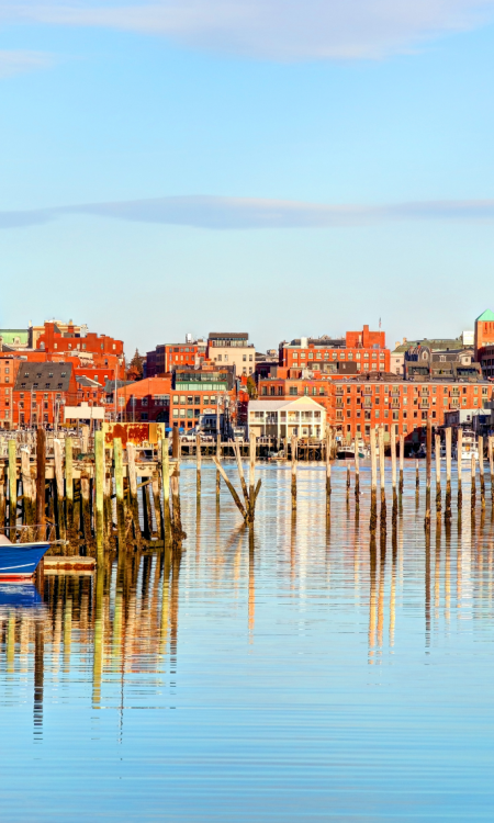 Hafen von Portland in Maine mit Booten, Holzstegen und Stadtsilhouette bei ruhigem Wasser
