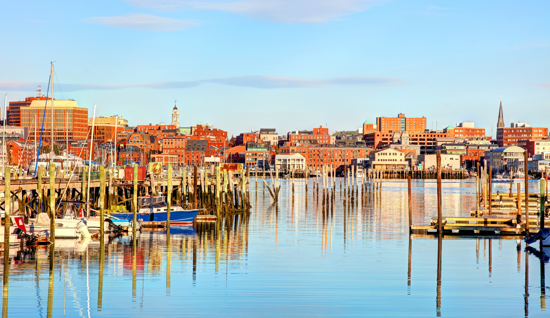 Hafen von Portland in Maine mit Booten, Holzstegen und Stadtsilhouette bei ruhigem Wasser