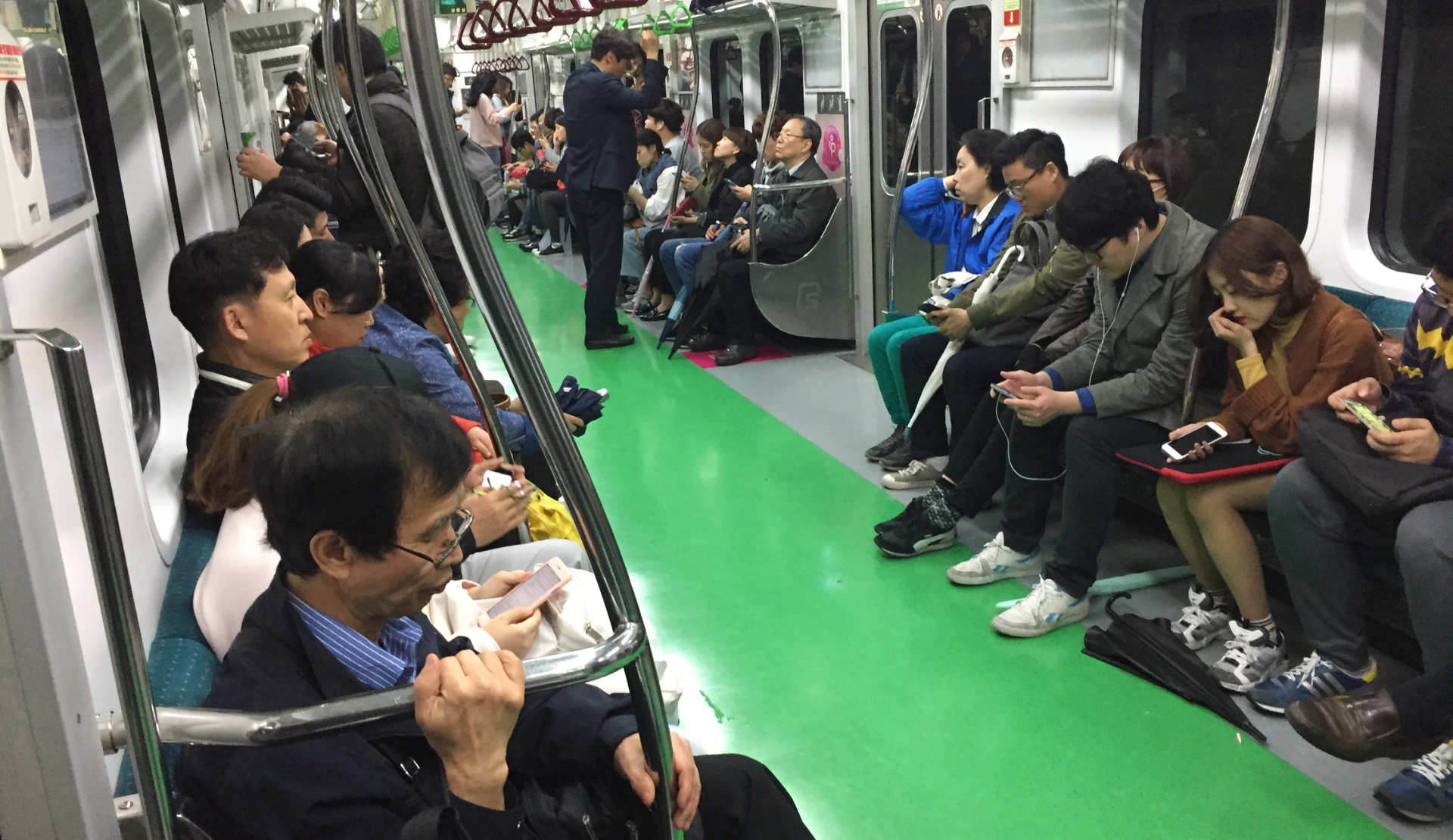 Fahrgäste in der Seouler Metro schauen auf ihre Smartphones