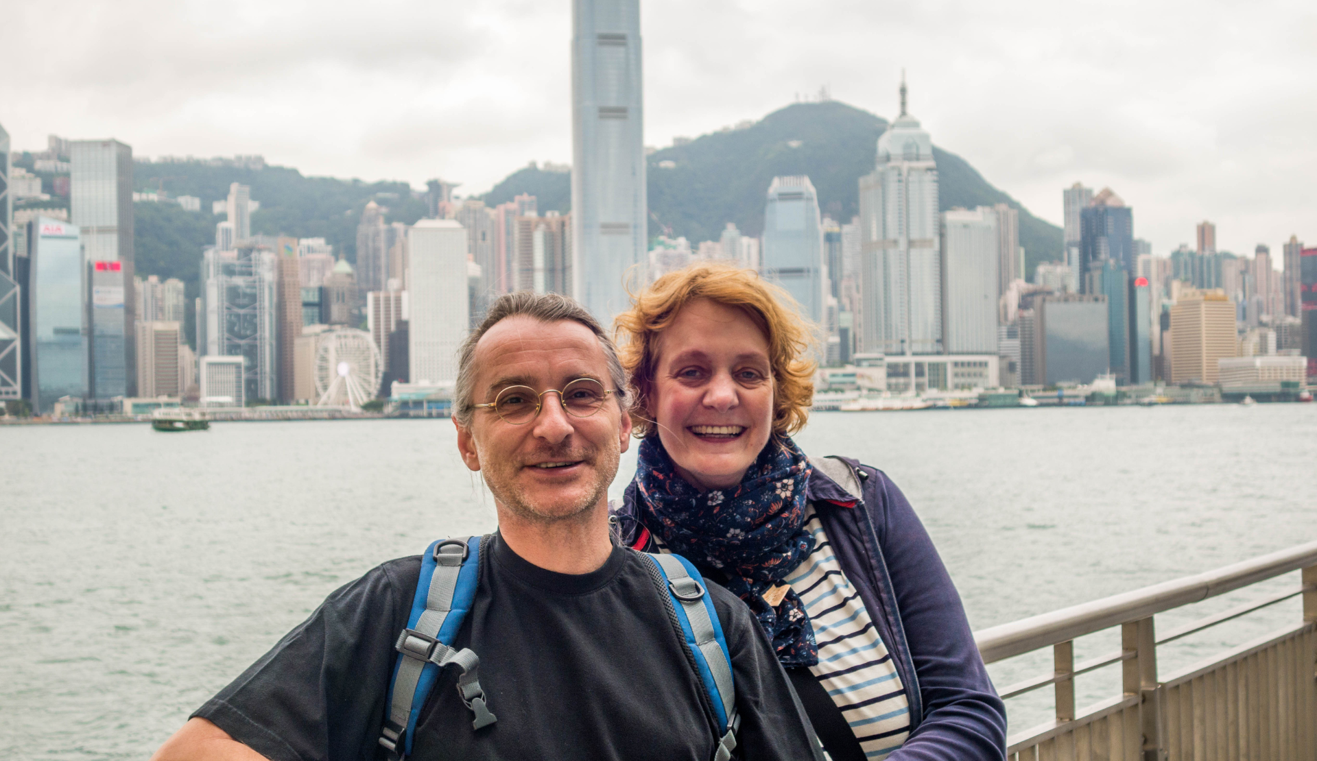 Reiseblogger vor der Skyline von Hongkong mit Victoria Harbour und Victoria Peak im Hintergrund