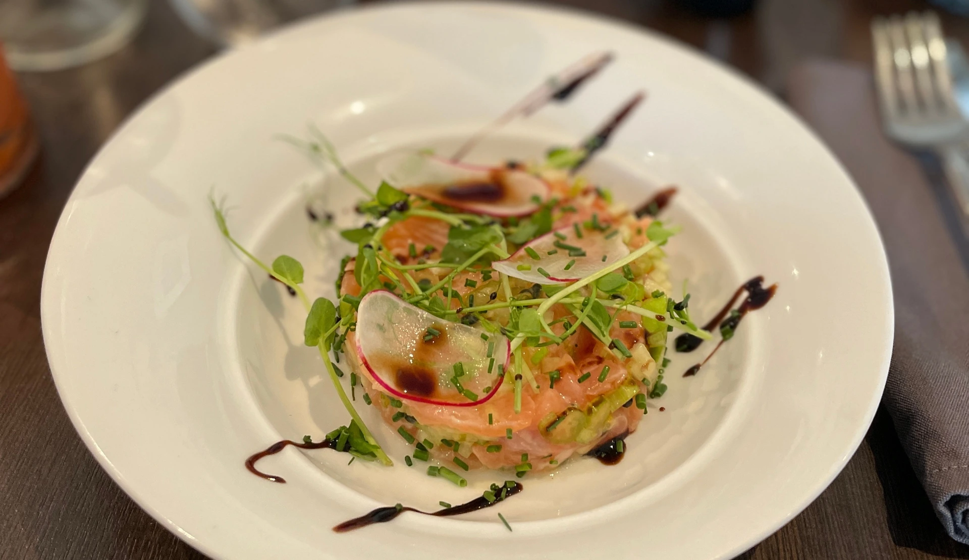 Fein angerichtete Vorspeise mit Fisch, Radieschen und Kräutern in einem bretonischen Restaurant