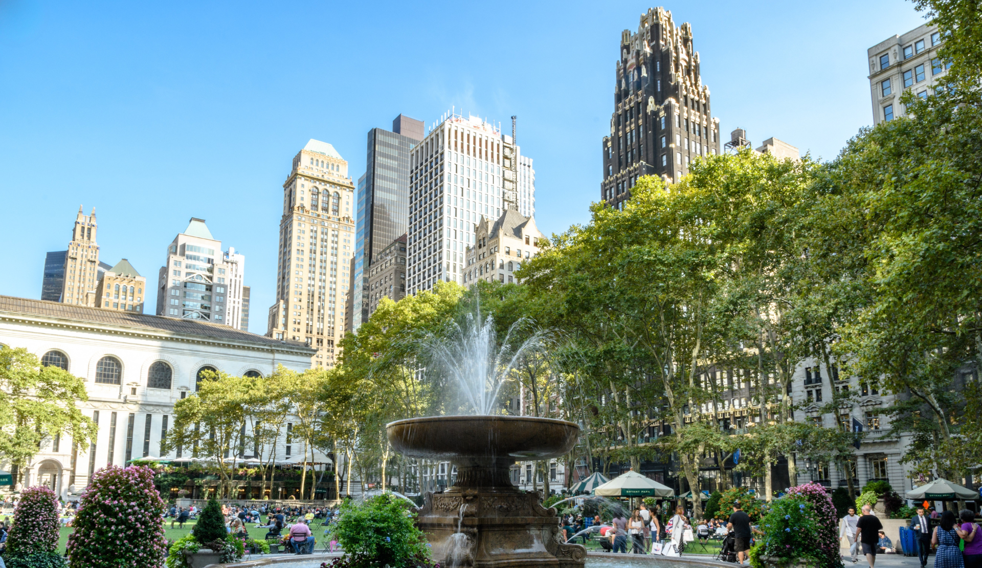 Bryant Park in New York mit Brunnen, Bäumen und Hochhäusern im Hintergrund