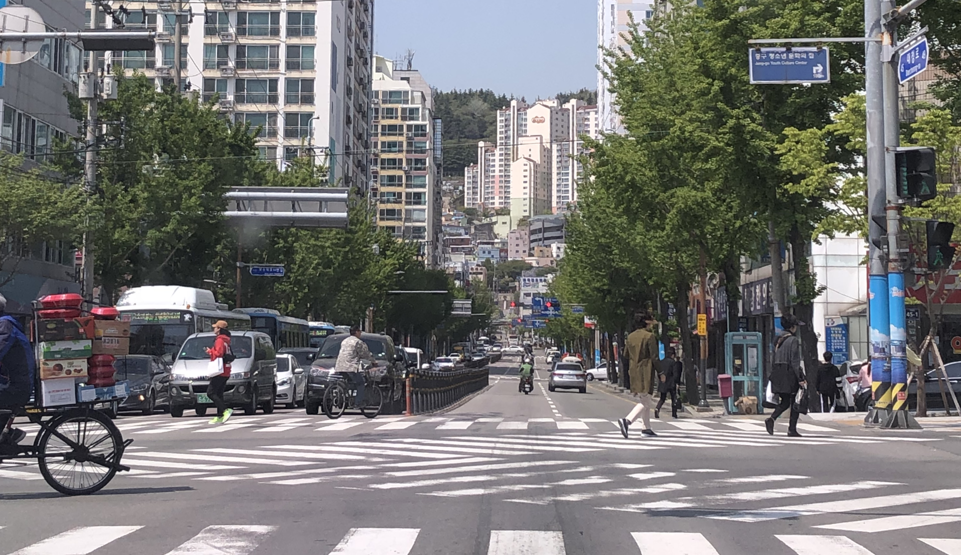 Straßenkreuzung in der Innenstadt von Busan Südkorea mit koreanischen Verkehrsschildern und Stadtbild im Hintergrund