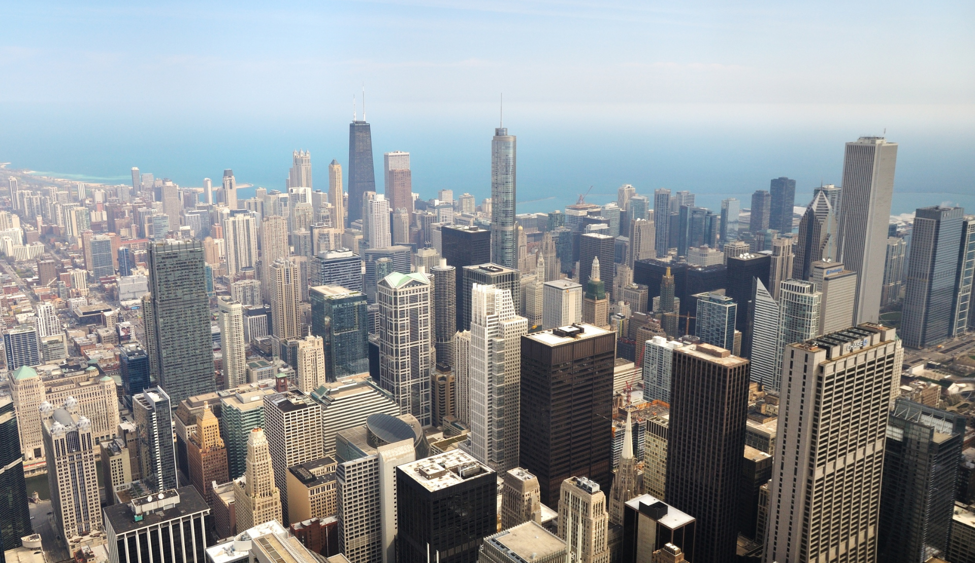  Luftaufnahme der Chicago Skyline mit Wolkenkratzern und dem Lake Michigan im Hintergrund