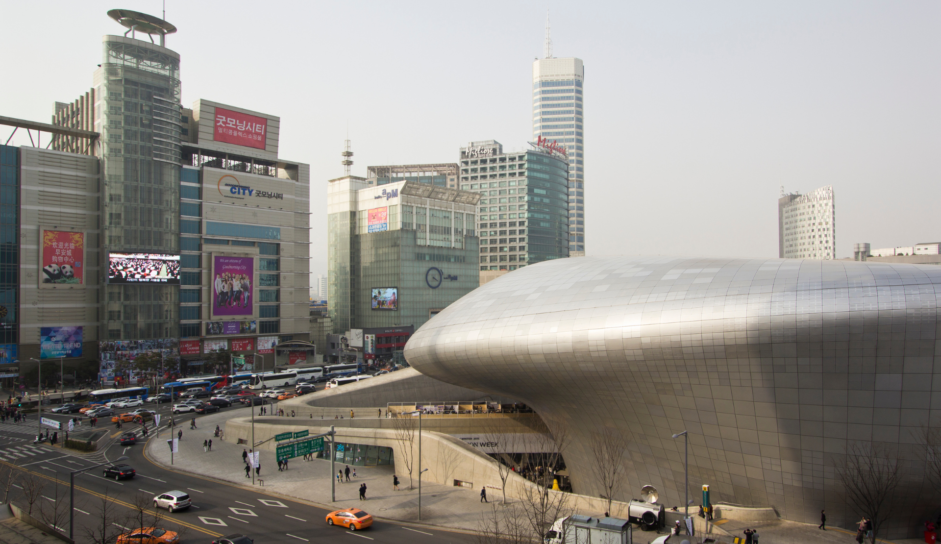 Das Dongdaemun Design Plaza DDP in Seoul mit seiner geschwungenen silbrigen Fassade von Zaha Hadid und den umliegenden Einkaufszentren