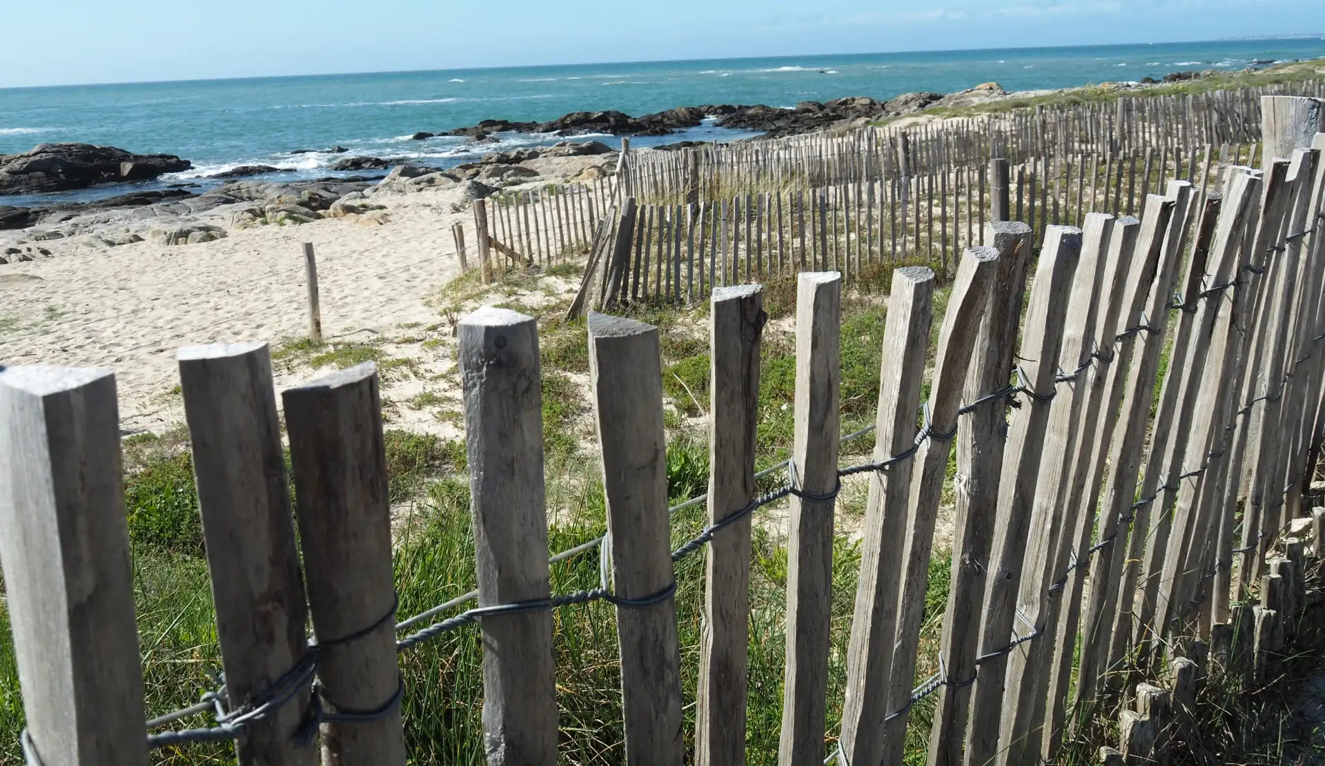 Sandiger Küstenweg mit Dünenzaun zum Strand bei Le Croisic in der Bretagne