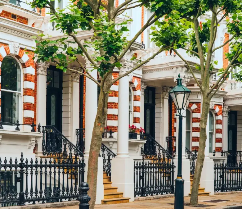 Weiße Stuckhäuser mit schmiedeeisernen Geländern in einem eleganten Viertel in London.