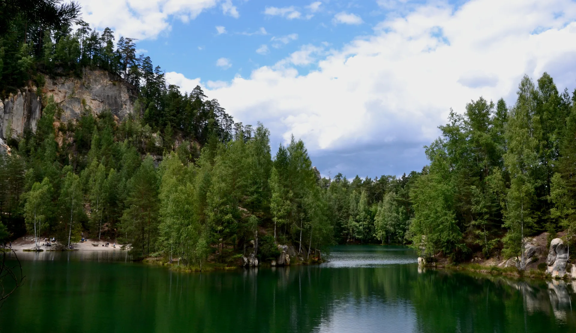 Türkisgrüner Felsensee Pískovna in der Adersbacher Felsenstadt, umgeben von Wald und Sandsteinfelsen