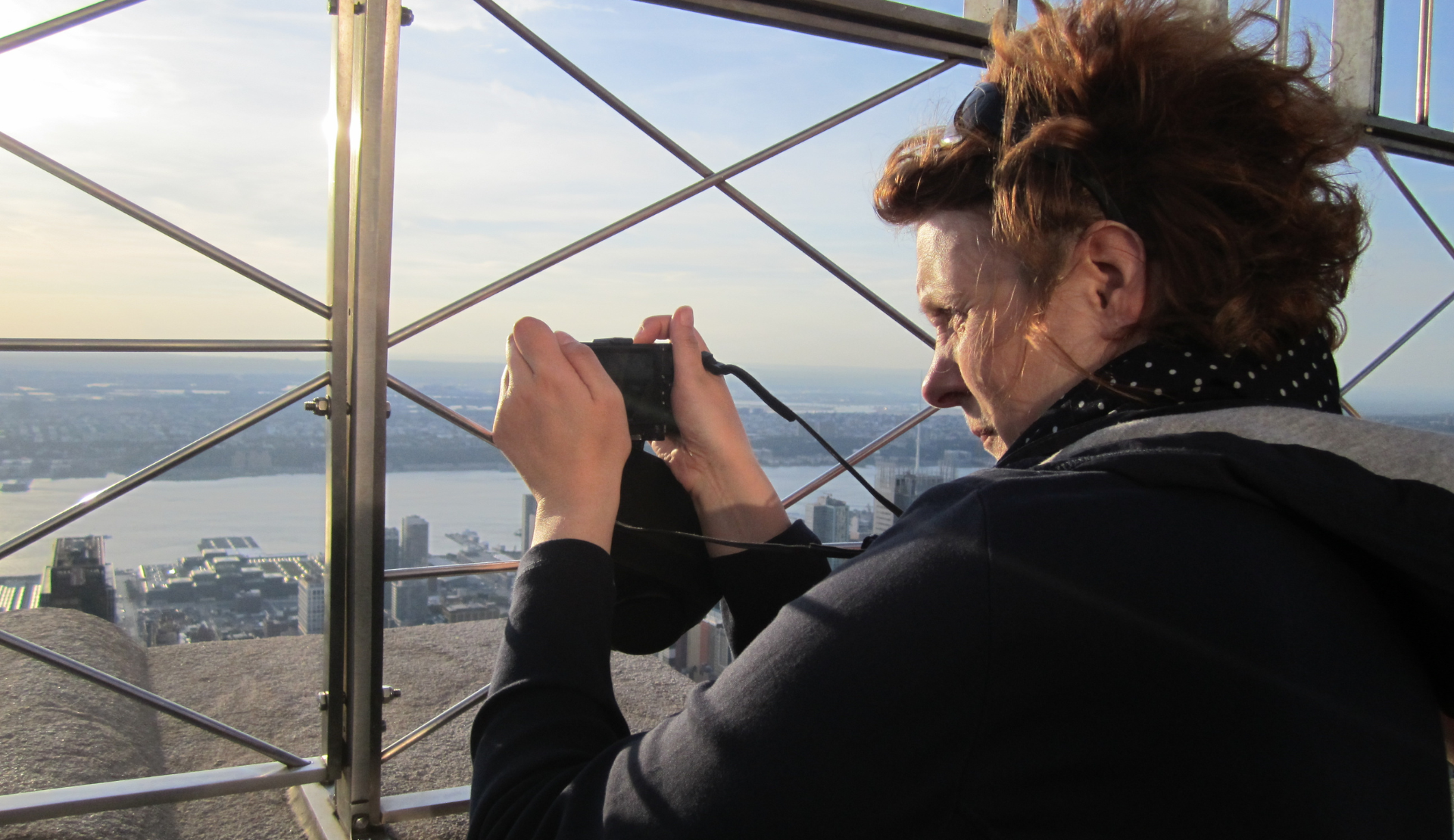 Frau fotografiert die Aussicht über New York City von einer Aussichtsplattform