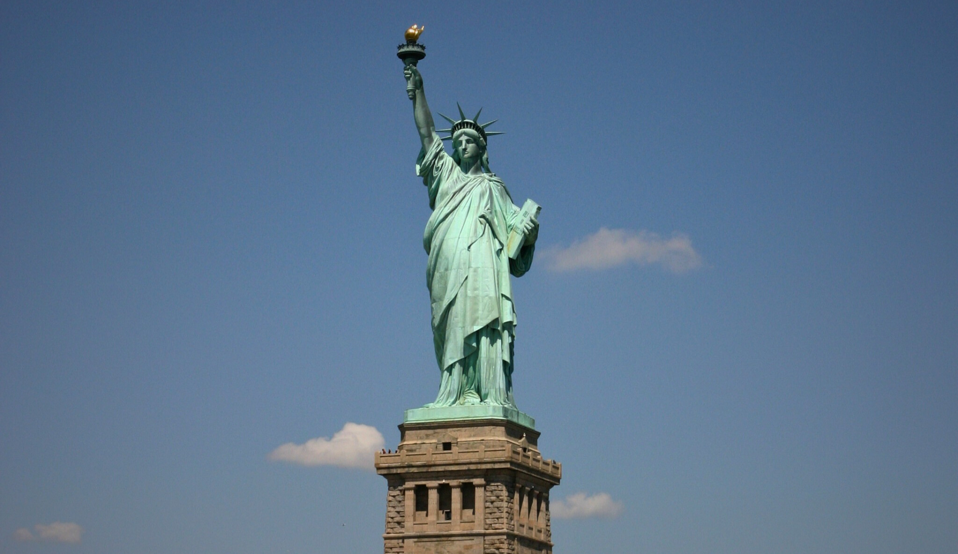 Freiheitsstatue in New York auf Liberty Island vor blauem Himmel