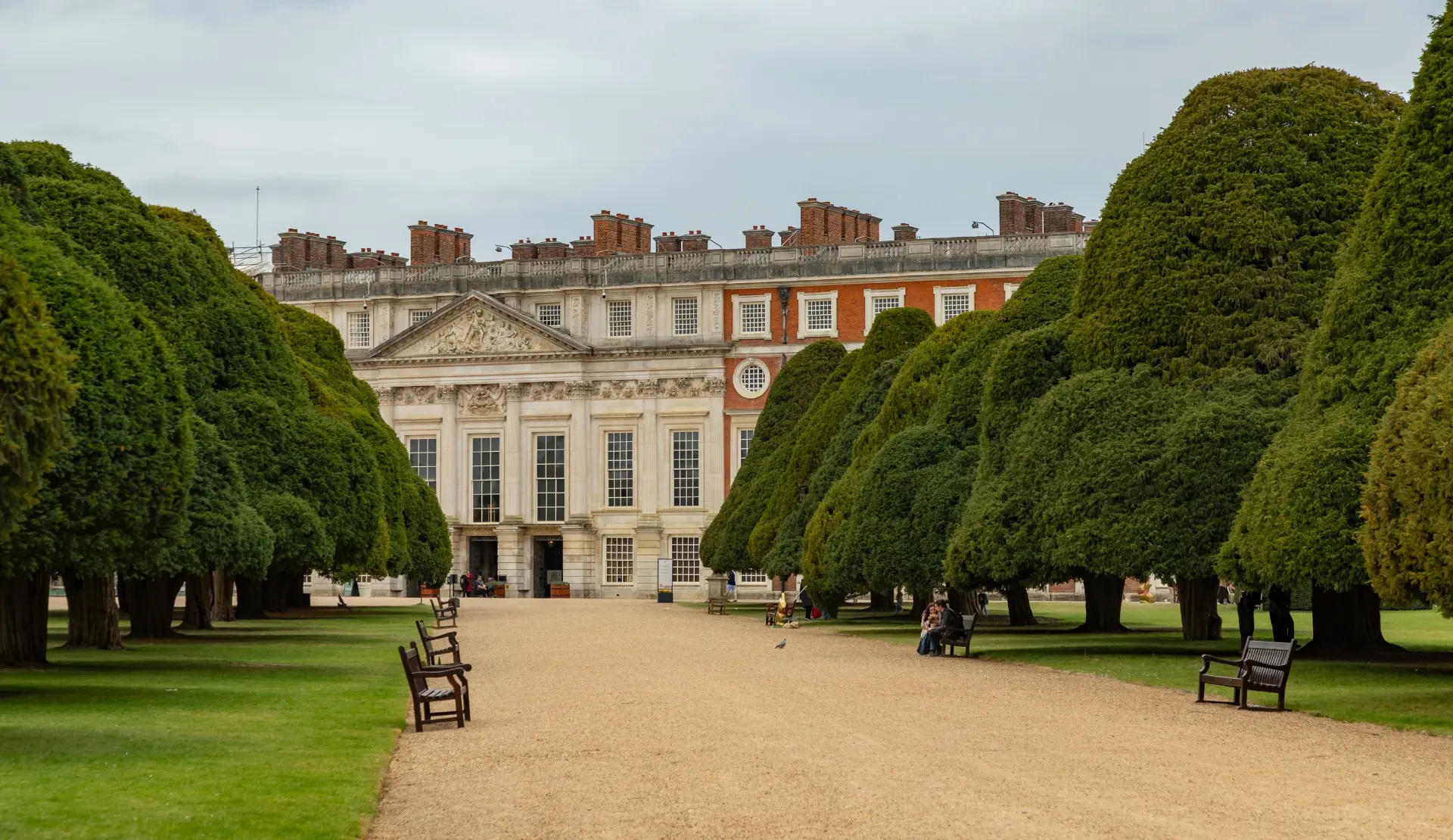 Hampton Court Palace mit geschnittenen Formhecken und Kiesweg im Vordergrund