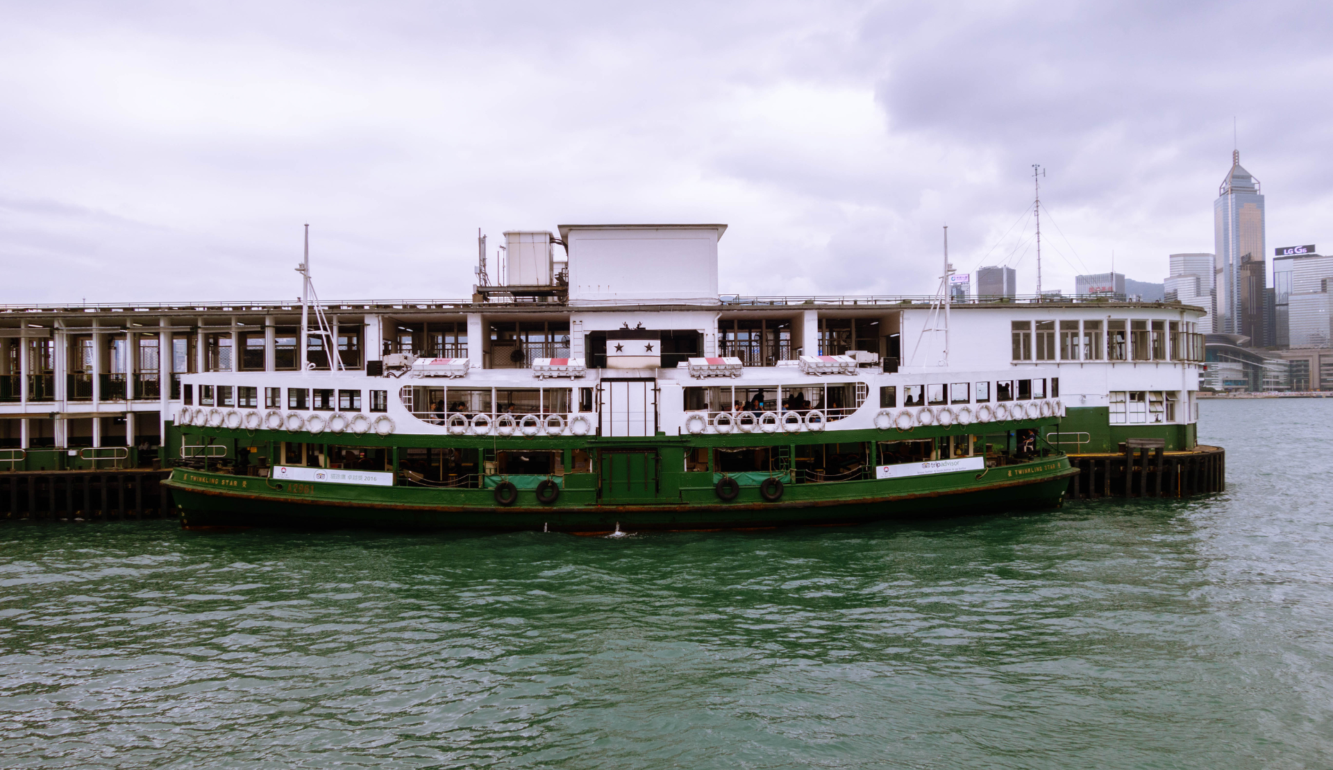 Grün-weiße Star Ferry auf dem Victoria Harbour in Hongkong mit Skyline im Hintergrund