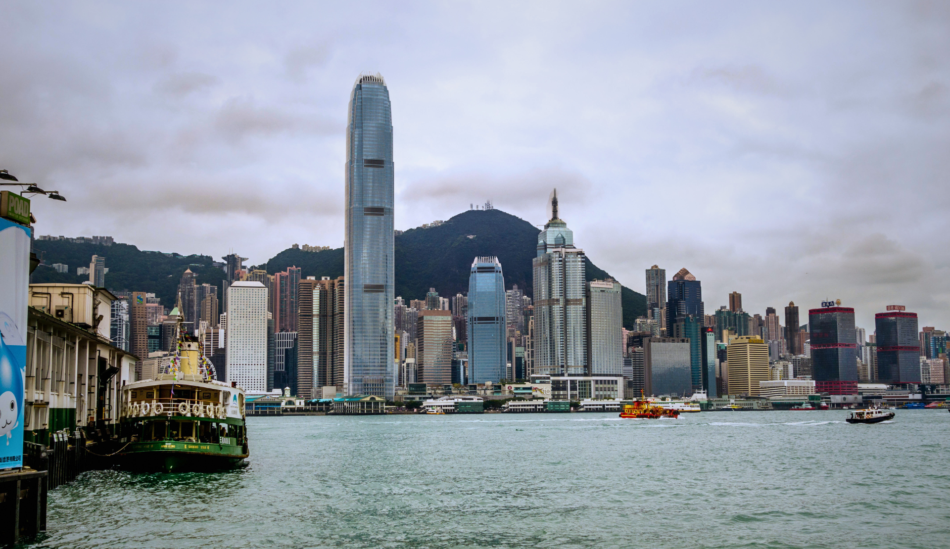 Blick über den Victoria Harbour auf die Hongkong Skyline mit International Commerce Centre Tower und historischer Star Ferry