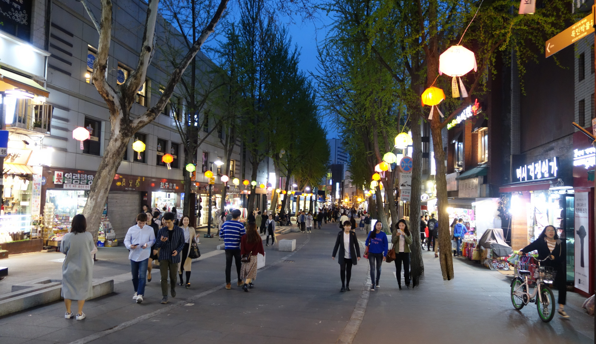 Belebte Straße in Insadong Seoul am Abend mit bunten Laternen und Geschäften auf beiden Seiten