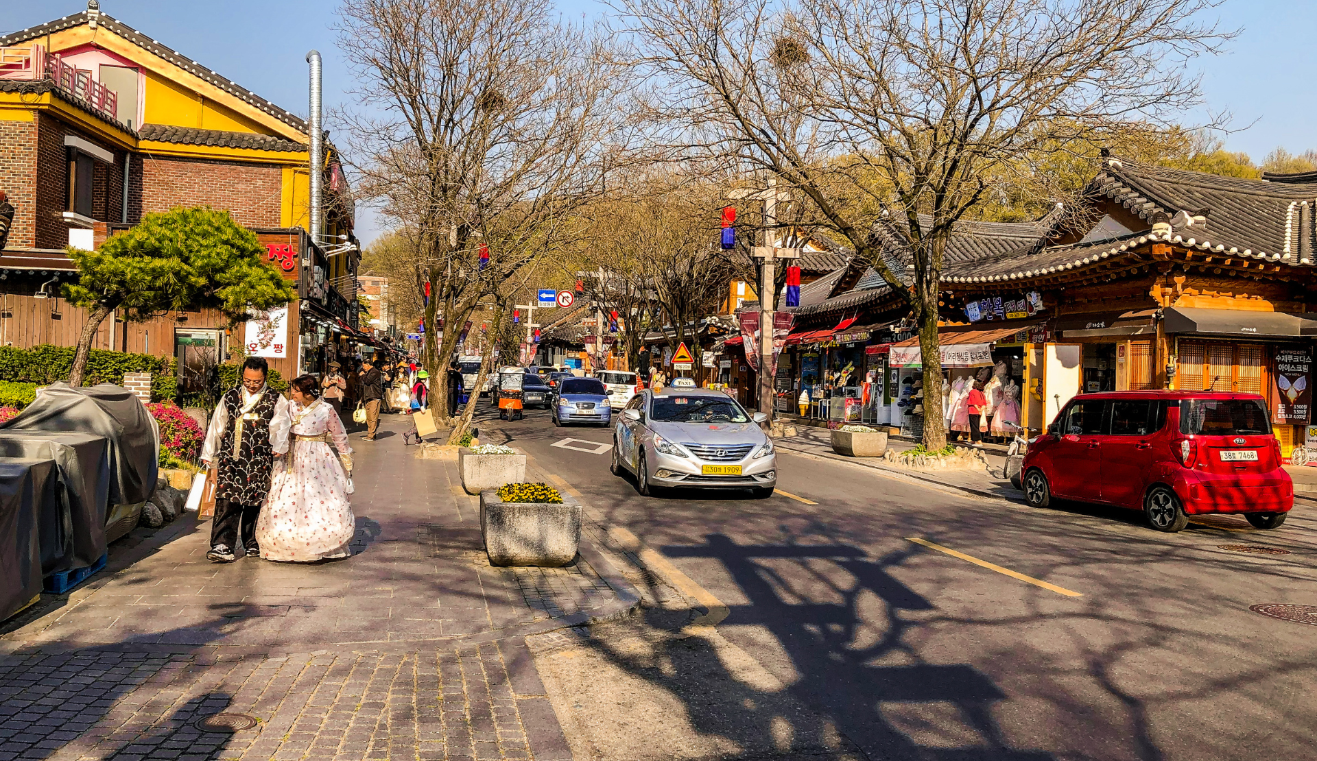 Belebte Straße im Jeonju Hanok Village mit Besuchern in traditionellen Hanbok-Gewändern und historischen Gebäuden