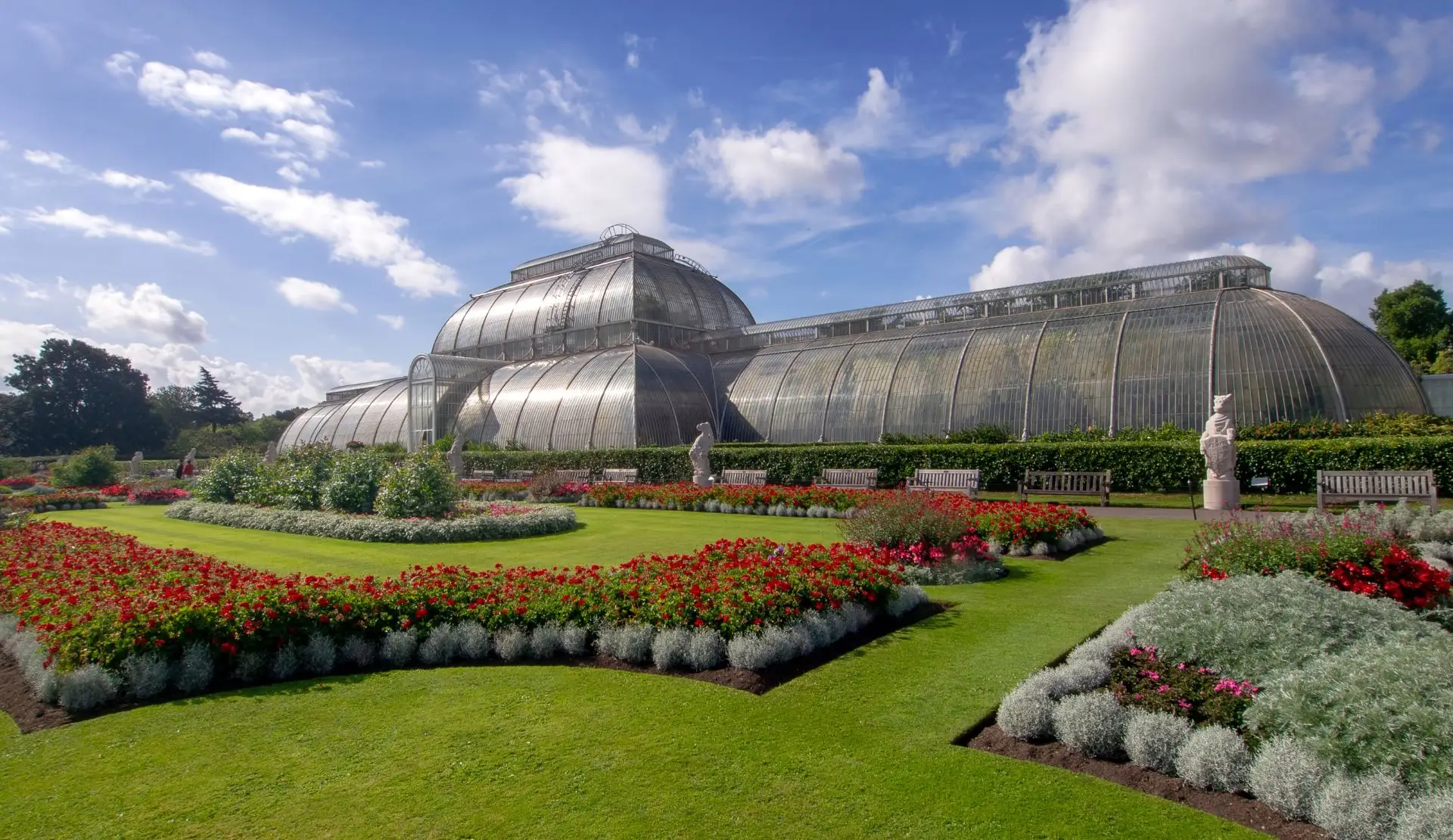 Palm House in Kew Gardens mit bunten Blumenbeeten im Vordergrund