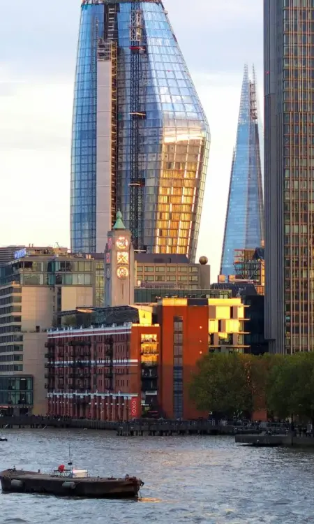 Skyline von London mit The Shard und Booten auf der Themse im Abendlicht