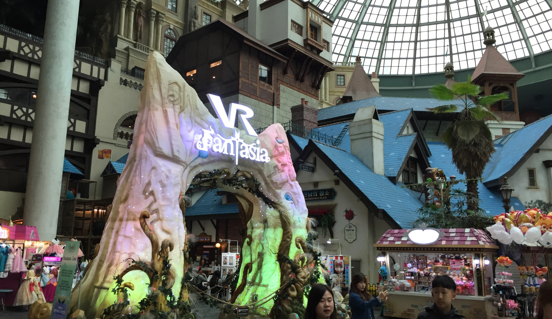  Blick in den Indoor-Bereich von Lotte World Adventure in Seoul mit bunten Dekorationen und dem charakteristischen Glasdach.