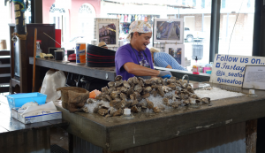 Mann verkauft Austern an einem Stand auf dem French Market in New Orleans