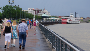 Spaziergänger auf dem Riverwalk am Mississippi in New Orleans mit Blick auf einen Raddampfer