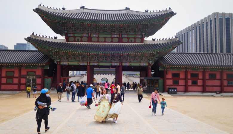 Besucher in traditionellen Hanbok-Gewändern vor dem Gyeongbokgung-Palast in Seoul