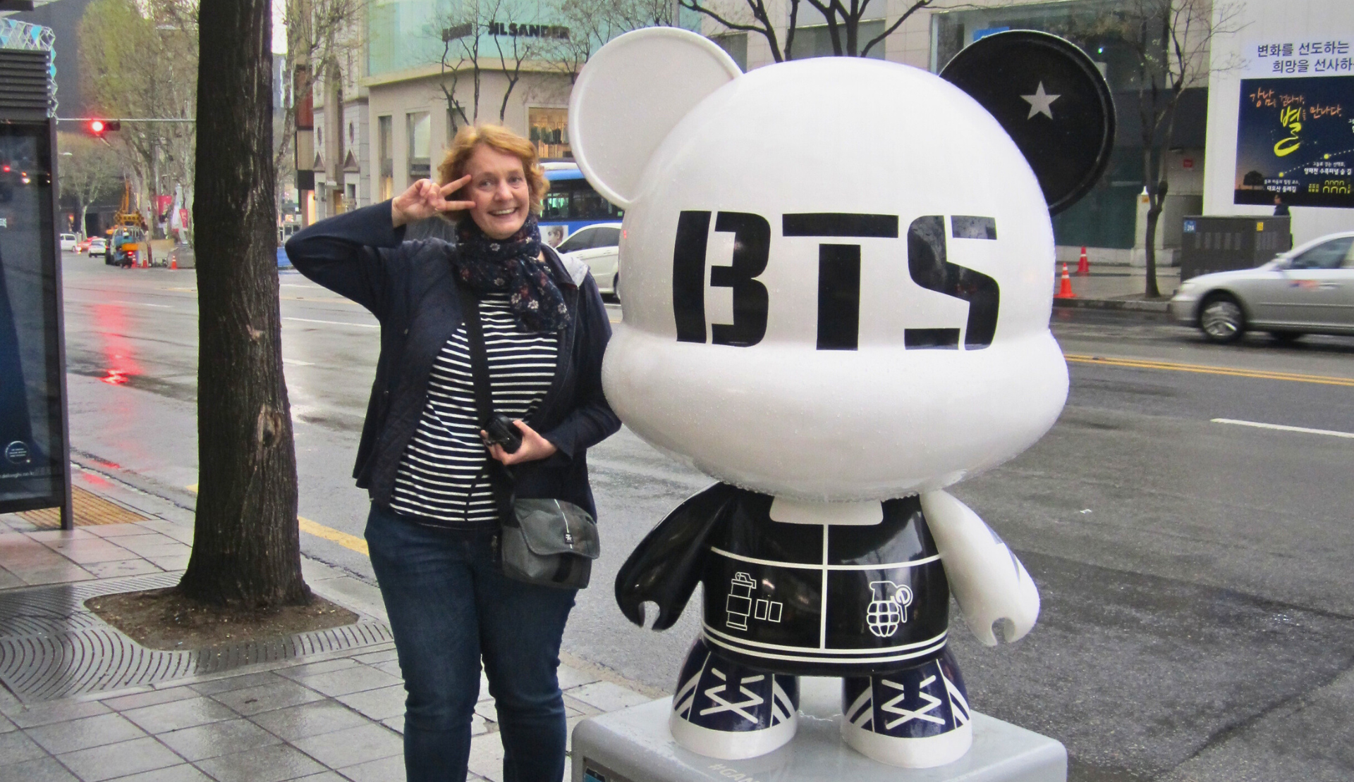Peggy neben einer großen BTS-Figur auf einer Straße in Seoul