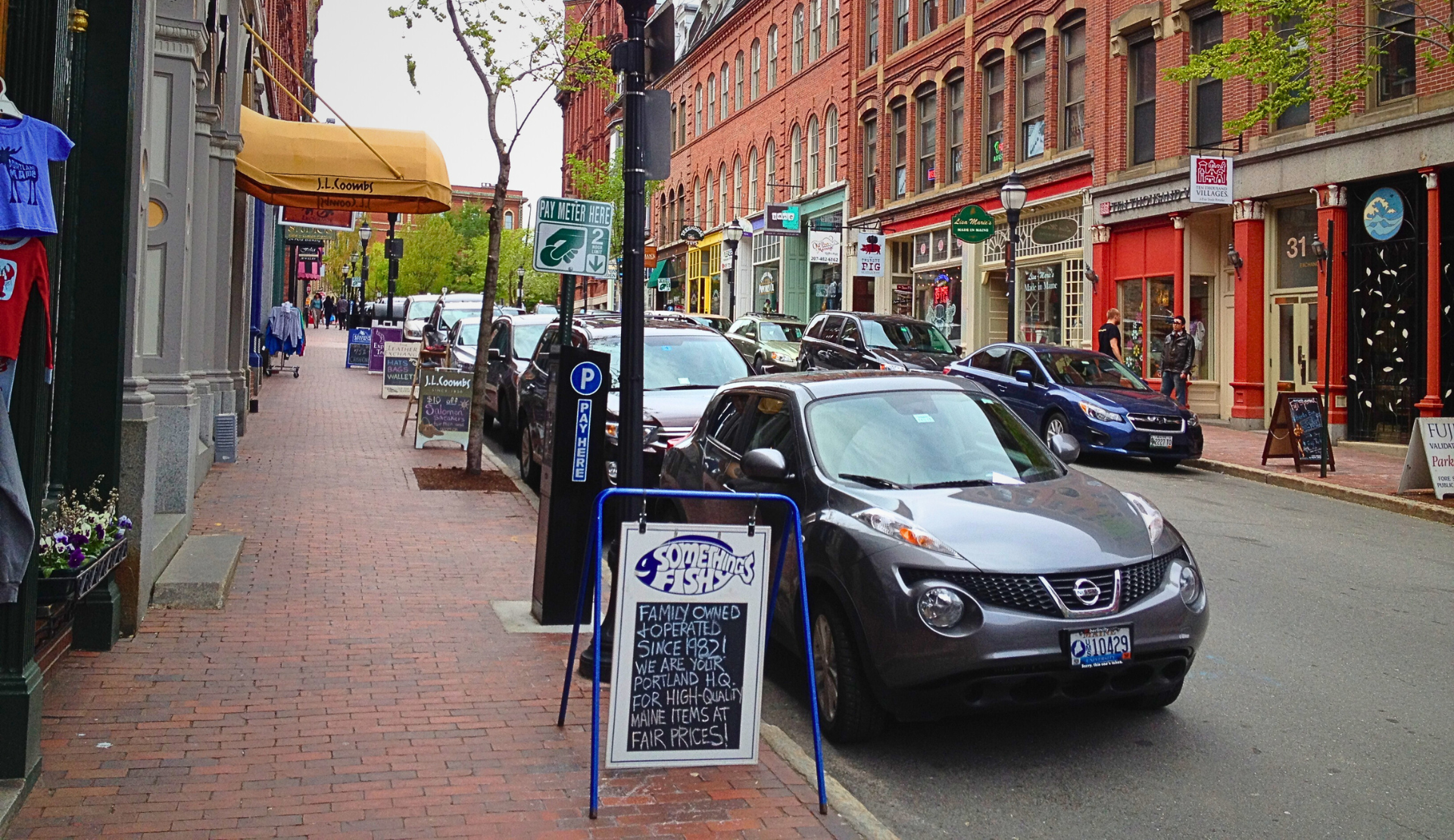 Straßenszene in der Altstadt von Portland Maine mit Backsteingebäuden, Geschäften und parkenden Autos