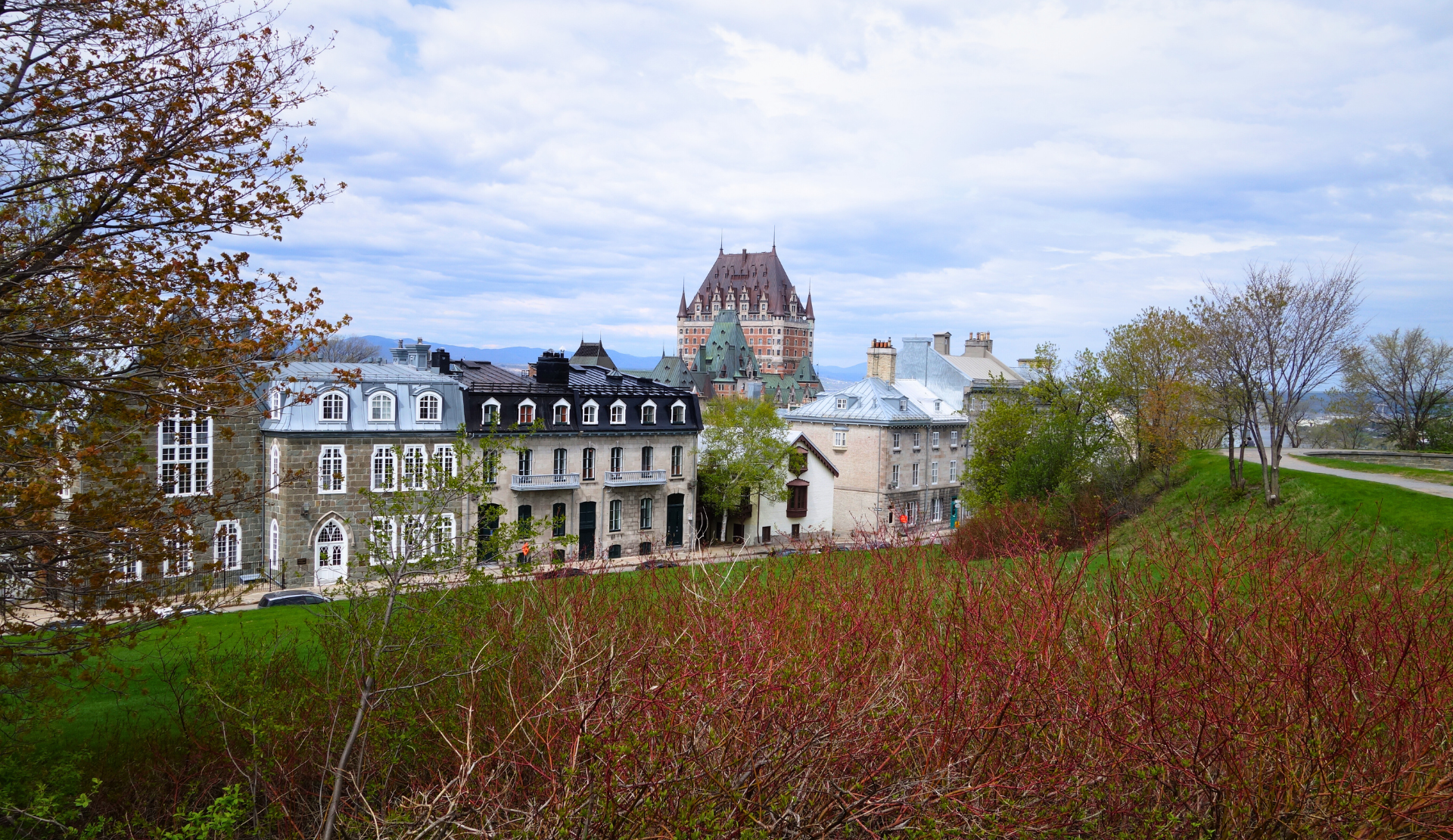 Blick auf das Château Frontenac in Quebec City mit Natur und historischen Häusern im Vordergrund