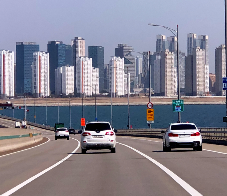 Autobahn in Südkorea mit moderner Stadtkulisse im Hintergrund