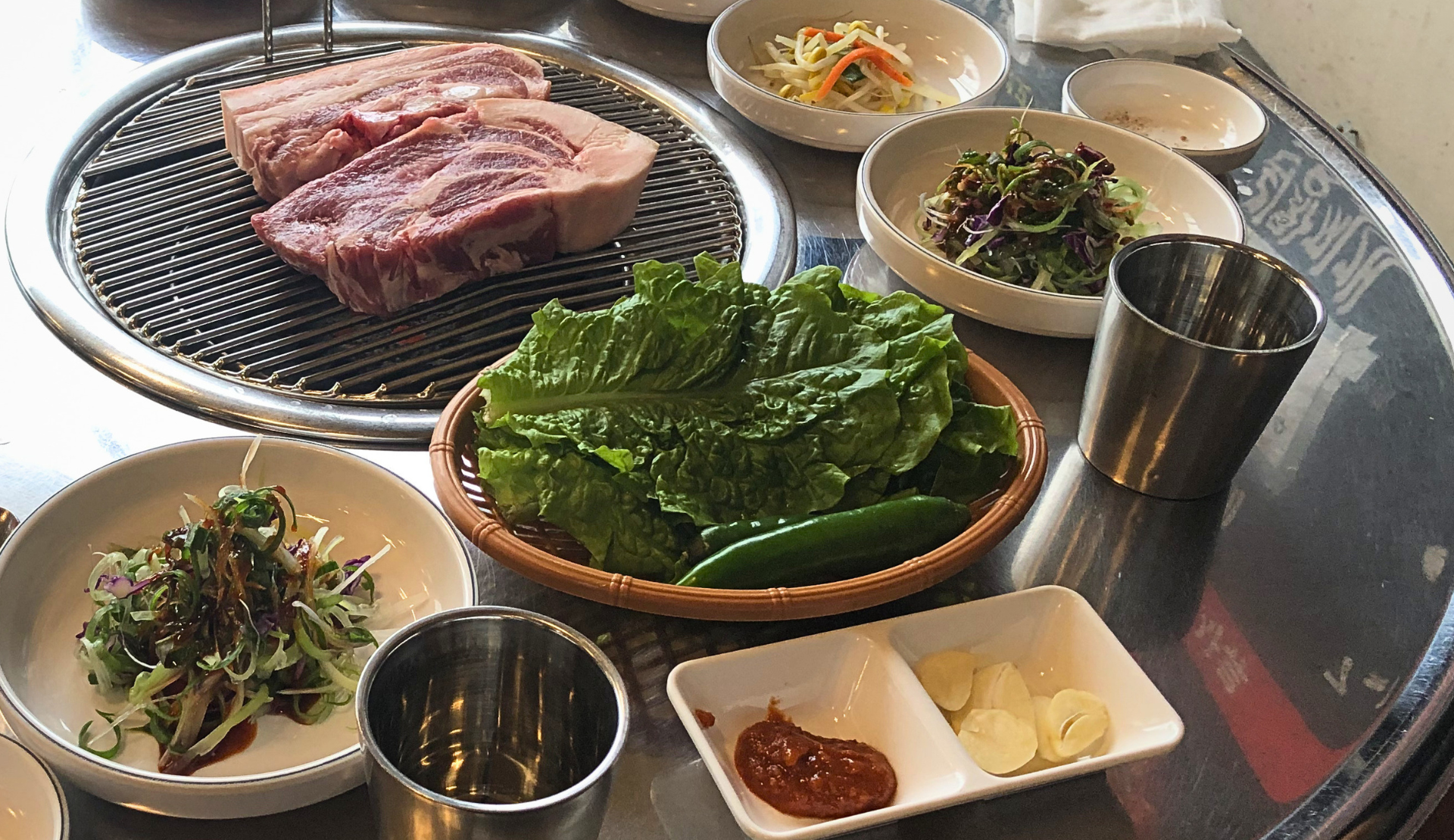 Schwarzes Jeju-Schwein auf dem Tischgrill mit koreanischen Beilagen auf Jeju Island Südkorea