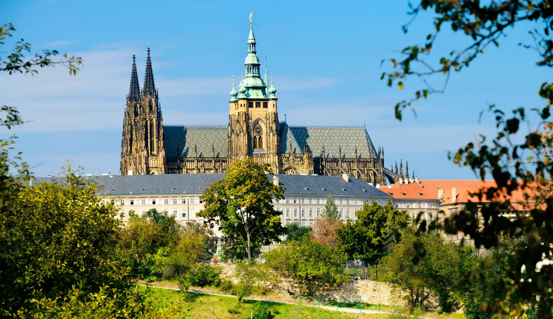 Der Veitsdom in Prag mit gotischen Doppeltürmen, umgeben von Bäumen