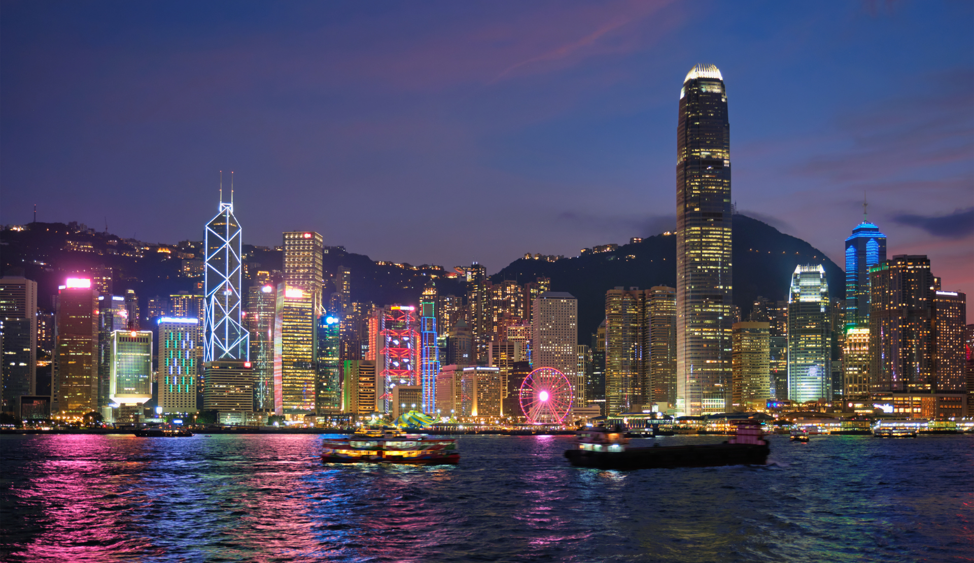 Hongkong Skyline bei Nacht mit leuchtenden Wolkenkratzern, Bank of China Tower und IFC Tower über dem Victoria Harbour während der blauen Stunde